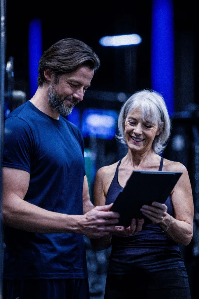 Coach accompagnant un adhérent en salle de sport GYM K